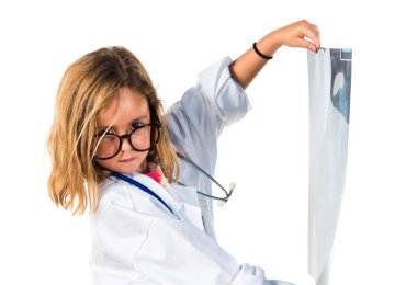 Little girl playing to be a doctor and holding a radiography clipart