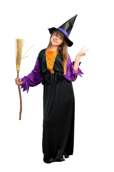 笑顔と勝利を示すサインに分離白ハロウィーンの休日のため 魔女に扮した少女のフルレングス ショット ロイヤリティフリーのストック写真