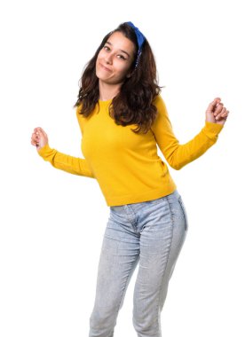 Sarı kazak ve kafasındaki mavi bandana ile genç kız zevk müzik izole beyaz zemin üzerinde bir partide dans