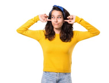 Sarı kazak ve her iki kulak izole beyaz arka plan üzerinde elleriyle kapsayan başında mavi bandana ile genç kız