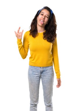 Sarı kazak ve kafasındaki kamera komik göz olması ve boynuzları izole beyaz zemin üzerine yaptırmayı dil gösterilen mavi bandana ile genç kız