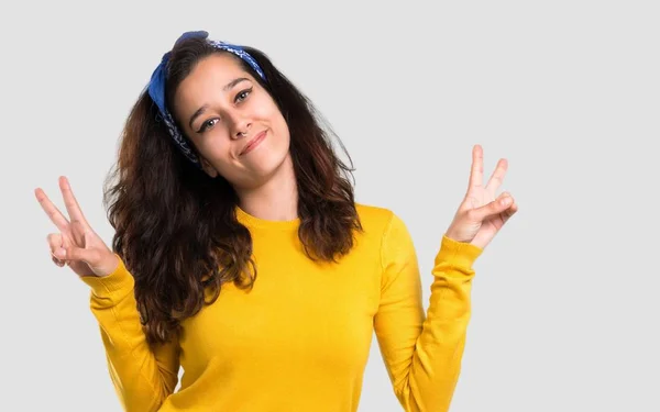 Menina Com Suéter Amarelo Bandana Azul Cabeça Sorrindo Mostrando Sinal — Fotografia de Stock