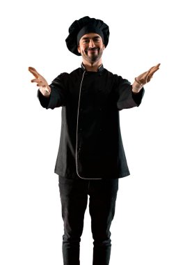 Eller yana uzanan ve sunulması ve izole beyaz zemin üzerine gelmek için davet için gülümseyen siyah üniformalı erkeklere Şef