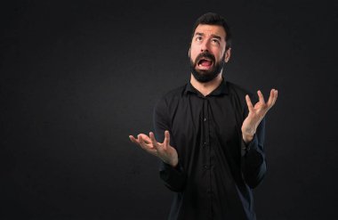 Siyah arka plan üzerine sakallı sinirli yakışıklı adam