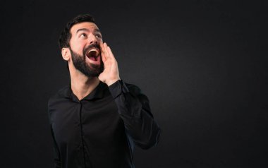 Siyah arka plan üzerine bağırarak sakallı yakışıklı adam