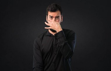 Siyah arka plan üzerine kötü jest kokulu yapma sakallı yakışıklı adam