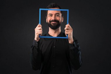 Siyah arka plan üzerine framework ile sakallı yakışıklı adam