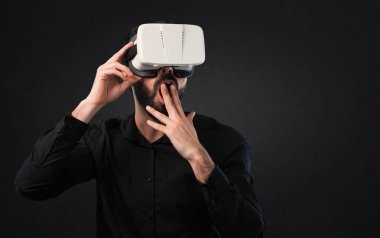 Siyah arka plan üzerine Vr gözlükle sakallı yakışıklı adam