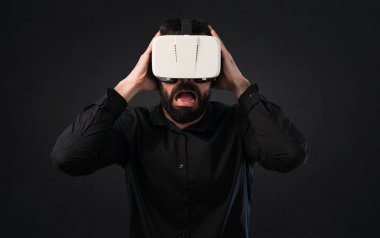 Siyah arka plan üzerine Vr gözlükle sakallı yakışıklı adam