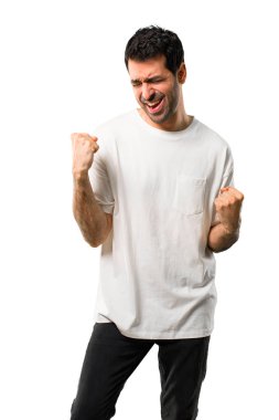 Beyaz arka plan beyaz gömlek bir ödül olarak kazandığı için mutlu ve zafer bir kutlama ile genç adam izole