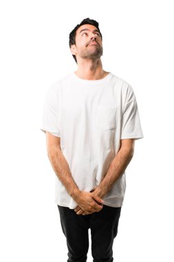 Genç adam beyaz gömlek stand ve izole beyaz zemin üzerine ciddi bir yüz ile seyir