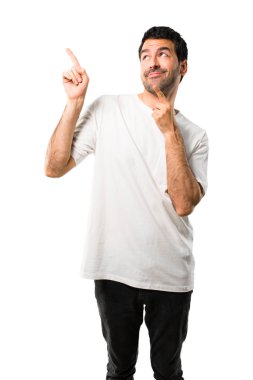 Harika bir fikir işaret parmağı ile işaret ve izole beyaz arka plan üzerinde ararken beyaz gömlek ile genç adam
