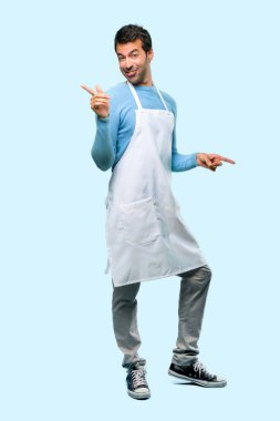 Bir önlük giyen adamın tam vücut zevk müzik mavi zemin üzerine bir partide dans