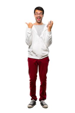 Bir adam gözlük ve her iki el ile jest Yaşasın vererek ve gülümseyen müzik dinleme tam uzunlukta bir kadeh. Beyaz arka plan üzerinde neşeli ifade