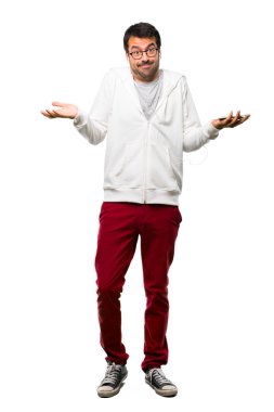 Adam tam vücut ile gözlük ve dinleme müzik yapım önemsiz ve omuz ve ellerde beyaz arka plan üzerinde kaldırma sırasında şüpheler jest