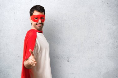 Süper kahraman maske ve kırmızı pelerin el sıkışma dokulu gri arka plan üzerinde iyi bir anlaşma sonra adamla