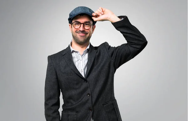快乐英俊的现代男子与贝雷帽和眼镜灰色背景 — 图库照片
