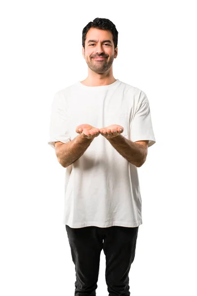 孤立した白い背景に広告を挿入する Copyspace を保持するには 想像上の手のひらの白いシャツと若い男 — ストック写真