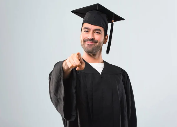 彼の卒業の日の大学の男灰色の背景に自信を持って式にあなたに指をポイントします — ストック写真