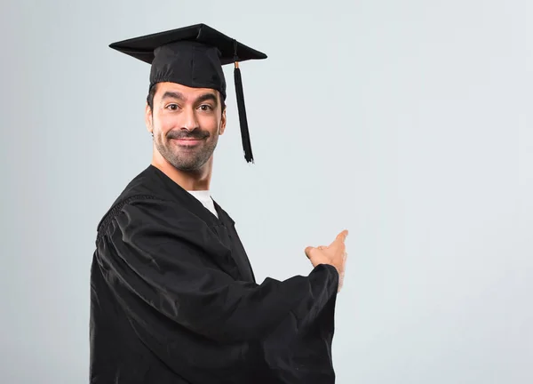 Άνθρωπος Στο Του Αποφοίτηση Ημέρα Πανεπιστήμιο Δείχνοντας Πίσω Δάχτυλο Δεικτών — Φωτογραφία Αρχείου