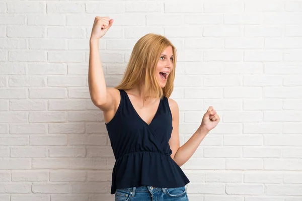 Blonde Woman Celebrating Victory Happy Having Won Prize White Brick — Stock Photo, Image