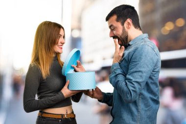 Adam ve bir hediye odaklanmamış arka planda tutan kadın