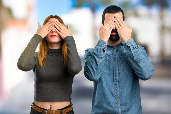 男人和女人覆盖他们的眼睛在不聚焦的背景 — 图库照片