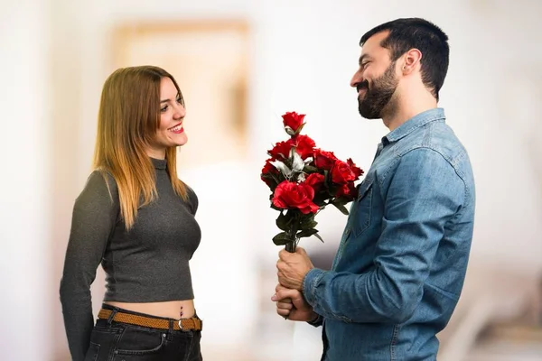 男と女のやり場のない背景に花を持って — ストック写真