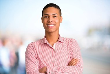 Silah tutan genç Afro-Amerikan adam ön konumda geçti. Kendine güvenen ifade odaklanmamış açık arka plan üzerinde