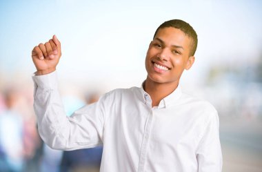 Genç Afro-Amerikan adam zevk müzik odaklanmamış açık arka plan üzerinde bir partide dans