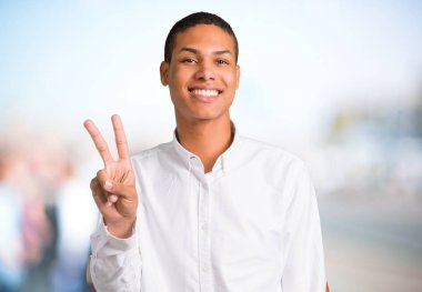 Parmakları odaklanmamış açık arka plan üzerinde beyaz gömlek mutlu ve sayım iki genç Afro-Amerikan adamla