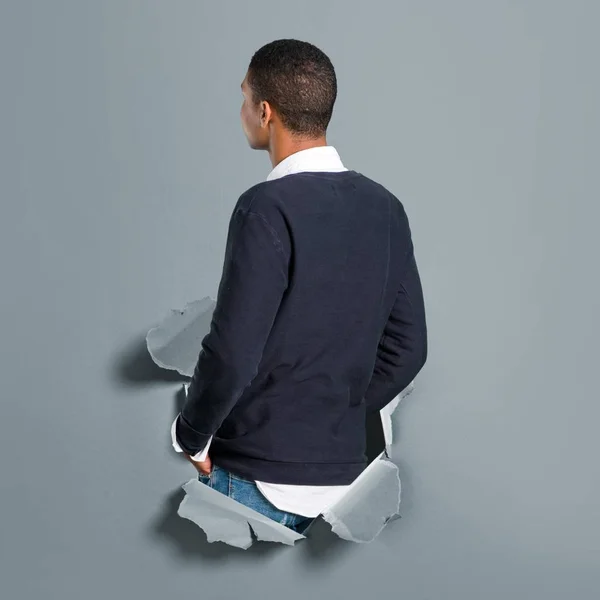 Jonge Afro Amerikaanse Man Terugkijkend Door Een Gat Van Papier — Stockfoto