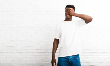 Gözleri eller tarafından kapsayan adam koyu tenli. Bir şey görmek istiyor musunuz