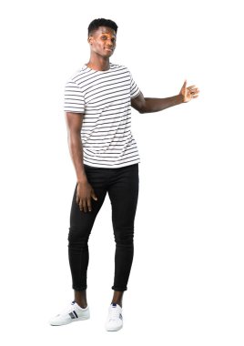 Çizgili gömlekli geri beyaz arka plan üzerinde bir ürün sunan işaret parmağı ile işaret ile adam tam vücut karanlık tenli