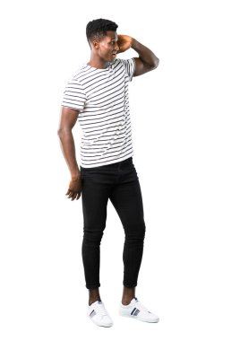 Çizgili gömlekli bir şey beyaz arka plan üzerinde dinleme ile adam tam vücut karanlık tenli