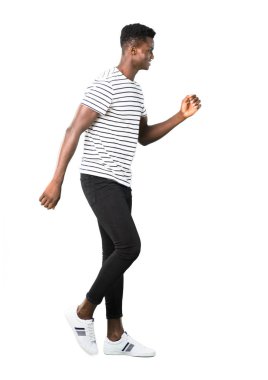 Karanlık tam vücut yürüme çizgili gömlekli adam derili. Hareket jest. Beyaz arka plan üzerinde