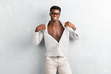 Dokulu gri duvara poz gözlüklü genç afro Amerikalı adam