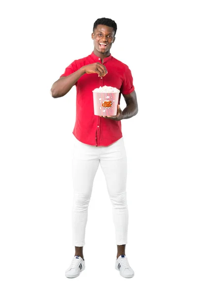 白い背景上に大きなボウルにポップコーンを食べる若いアフリカ系アメリカ人の完全なボディ — ストック写真