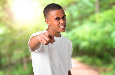 Genç Afro-Amerikan adam Öfkeli öfkeli jest olarak rahatsız. Kötü bir durum ve açık bir parkta işaret tarafından hayal kırıklığına