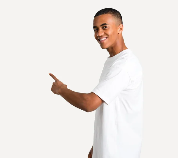 Młody Człowiek African American Wskazując Powraca Palcem Wskazującym Prezentując Produkt — Zdjęcie stockowe