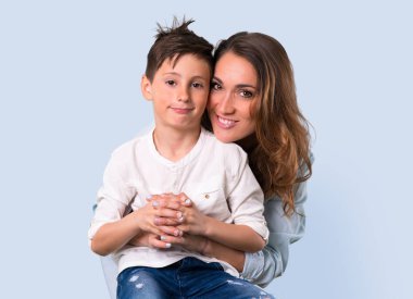 Anne ve kızı mavi arka plan üzerinde gülüyor