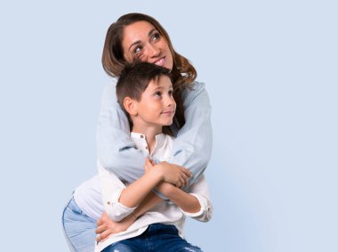 Anne ve kızı işaret parmağı ile mavi arka plan üzerinde harika bir fikir