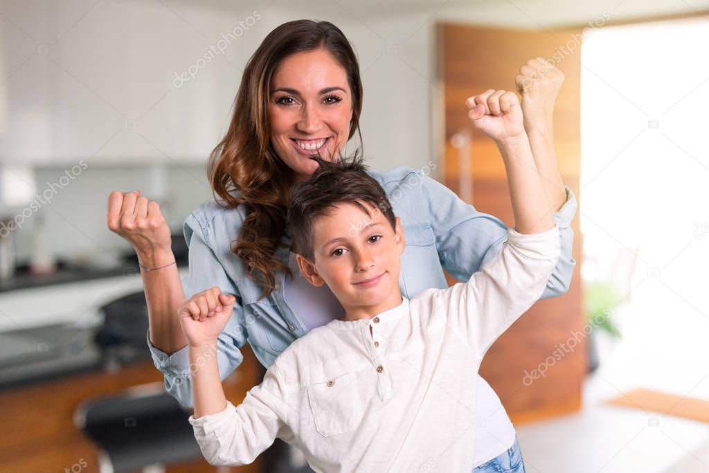 Mother and daughter celebrating a victory inside house