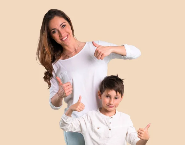 Mãe Filho Dando Gesto Polegar Para Cima Sorrindo Fundo Ocre — Fotografia de Stock