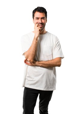 Beyaz gömlek izole beyaz arka plan üzerinde tatlı bir ifade ile gülümseyen genç adamla