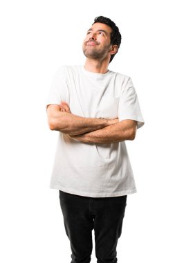 Genç adam beyaz gömlek stand ve izole beyaz arka plan üzerinde gülümseyen ararken