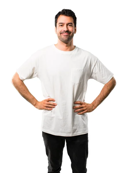 年轻的男人与白衬衫摆姿势与手臂在臀部和笑看着前面在孤立的白色背景 — 图库照片