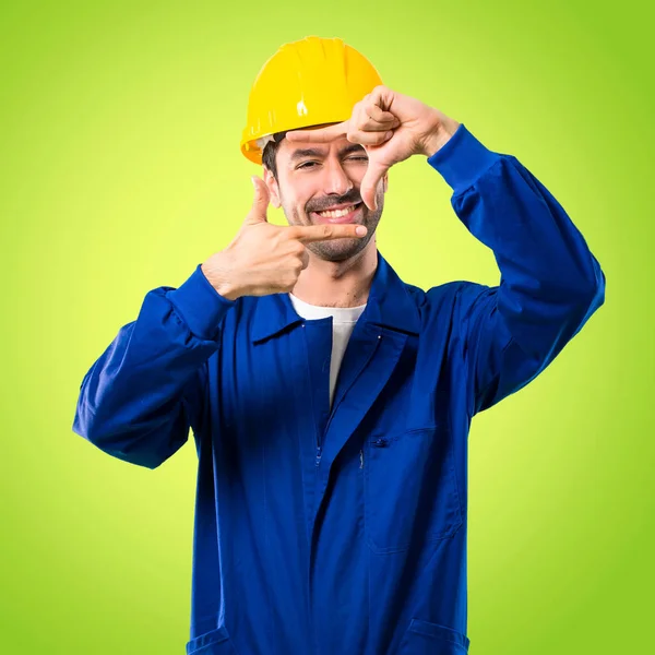 Junger Arbeiter Mit Helmfokussiertem Gesicht Rahmensymbol Auf Grünem Hintergrund — Stockfoto