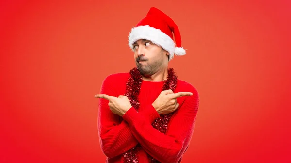 Man Red Clothes Celebrating Christmas Holidays Pointing Laterals Having Doubts — Stock Photo, Image