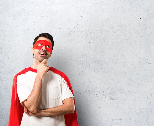 マスクと赤マントは 立って 織り目加工のグレーの背景上のアイデアを考えてスーパー ヒーロー男 — ストック写真